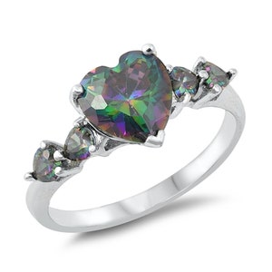 Op de afbeelding: Een zilveren ring met een grote, hartvormige, iriserende edelsteen, omringd door kleinere, iriserende edelstenen.