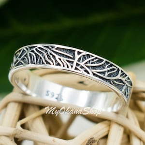 May include: A silver ring with a detailed tree branch design. The ring is marked with "925" on the inside.