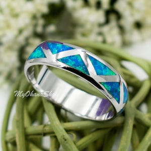 May include: A silver band ring with a blue and green opal inlay in a chevron pattern.