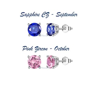 May include: Two pairs of silver stud earrings with round gemstones. The top pair features a blue sapphire CZ and the text "Sapphire CZ - September". The bottom pair features a pink zircon and the text "Pink Zircon - October".
