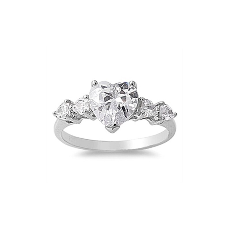 Op de afbeelding: Een zilveren ring met een grote, hartvormige, heldere steen en kleinere heldere stenen op de band.