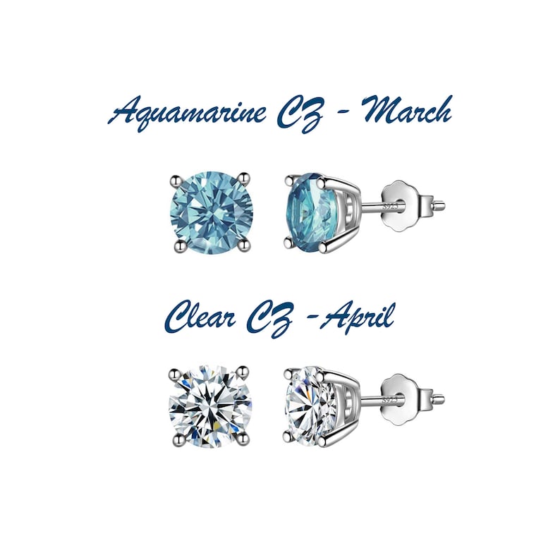 May include: Two pairs of silver stud earrings with clear cubic zirconia stones. The top pair features aquamarine blue stones and the text "Aquamarine CZ - March". The bottom pair features clear stones and the text "Clear CZ - April".