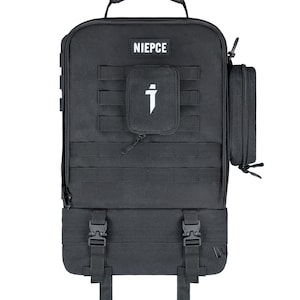 May include: A black tactical backpack featuring a top handle, a front patch with the text NIEPCE, a central small pouch with a white logo, and a side attachment. The bag includes horizontal webbing straps and two lower adjustable buckles with straps.