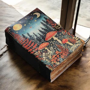 May include: A leather-bound journal with a colorful forest scene featuring mushrooms, trees, a moon, and stars. The journal has a metal clasp and aged paper pages. The cover art is a vibrant mix of blues, reds, and greens.
