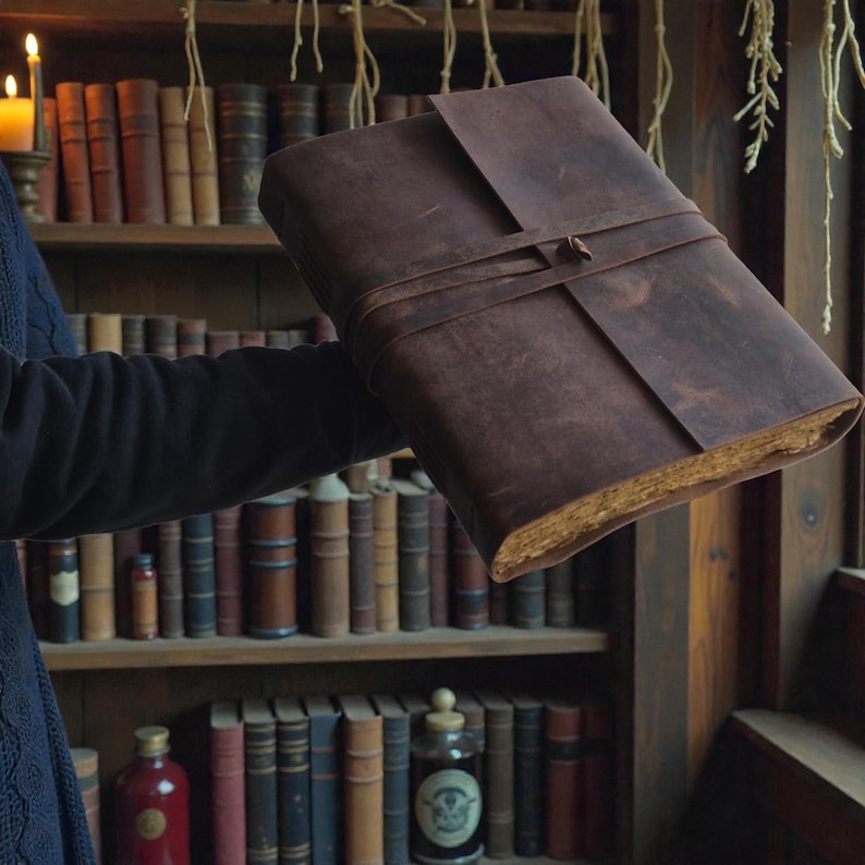 Handmade leatherbound journal with wrap strap, dark leather and deckle-edge pages; versatile grimoire for travel diary.