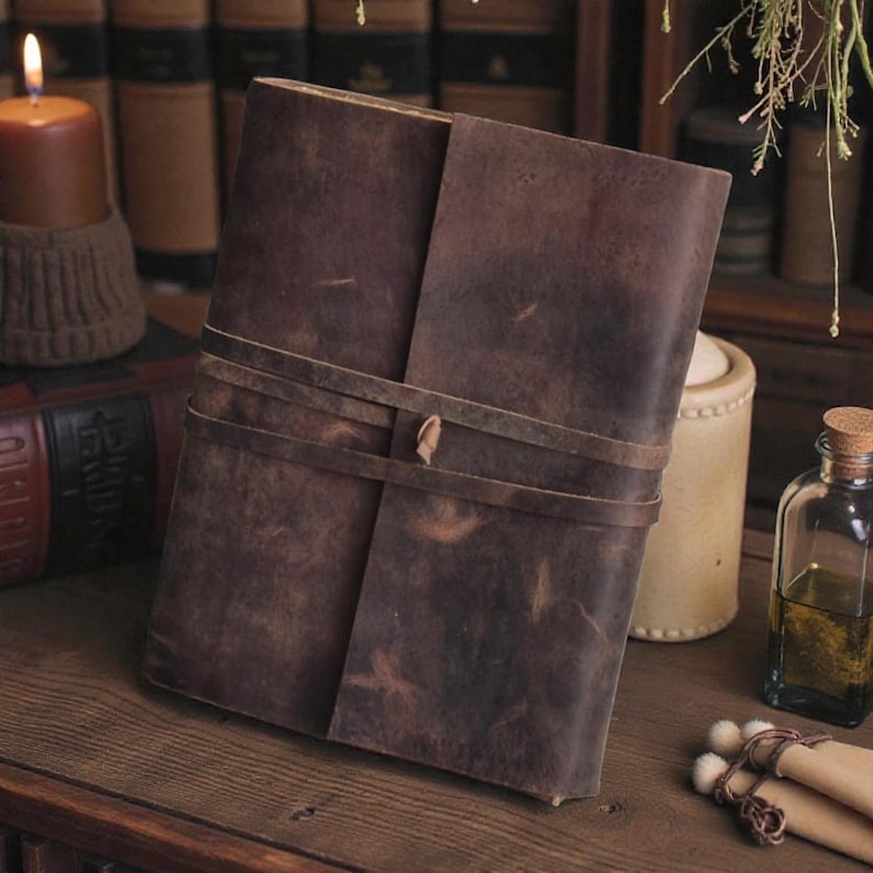 Handmade leatherbound journal with wrap strap, dark leather and deckle-edge pages; versatile grimoire for travel diary.