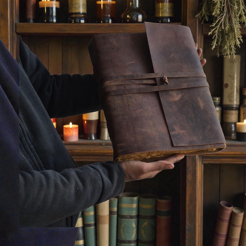 Handmade leatherbound journal with wrap strap, dark leather and deckle-edge pages; versatile grimoire for travel diary.
