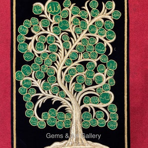Puede incluir: Un tapiz de pared de terciopelo negro con bordados dorados que representan un árbol de la vida con hojas verdes y ramas doradas. Las hojas están decoradas con caligrafía árabe en oro y verde. El texto en la parte inferior dice "Gems & Gallery".