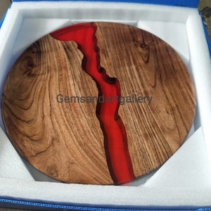 May include: A round wooden serving tray with a red epoxy resin river design. The tray is in a blue box with white foam padding.