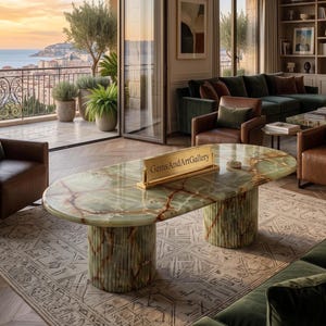 Pode incluir: Uma mesa de jantar oval feita de ônix verde polido com veios castanhos proeminentes, apresentando duas bases cilíndricas caneladas. Uma placa retangular dourada com o texto GemsAndArtGallery está posicionada no centro da mesa.
