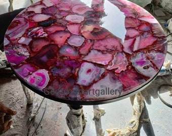 May include: A round table with a pink and purple agate stone top. The table has a black metal base.