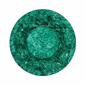 Puede incluir: Una tapa de mesa redonda de malaquita verde con un patrón de remolino orgánico. La tapa de la mesa tiene aproximadamente 30 cm de diámetro.