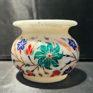 May include: A white alabaster vase with a floral design. The vase is decorated with colorful inlaid stones, including red, blue, green, and gold. The vase is approximately 4 inches tall.