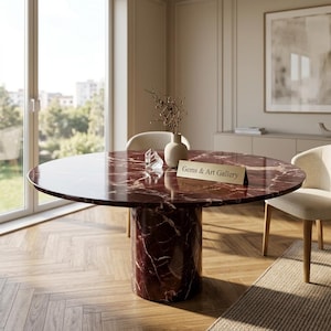Peut inclure: Une table ronde en marbre rouge vein&eacute; de blanc. Elle pr&eacute;sente un socle cylindrique et une surface polie. Une petite pancarte avec l'inscription "Gems & Art Gallery" est pos&eacute;e sur la table. Un vase avec des branches et un cristal sont &eacute;galement pr&eacute;sents.