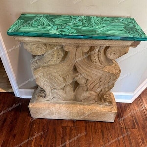 Puede incluir: Una mesa decorativa con una base de piedra tallada y una tapa de malaquita verde.