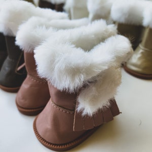 May include: A set of five pairs of faux fur-trimmed boots in brown, black, and gold. The boots have a variety of styles, including ankle boots and knee-high boots.