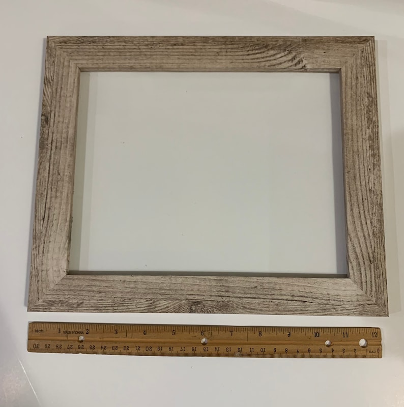 K&ouml;nnte beinhalten: Ein heller Holzbilderrahmen mit einem wei&szlig;en Passepartout und einer abgenutzten Oberfl&auml;che. Der Rahmen misst 30,5 cm x 40,6 cm.