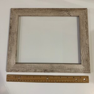 May include: A light wood picture frame with a white mat and a distressed finish. The frame measures 12 inches by 16 inches.