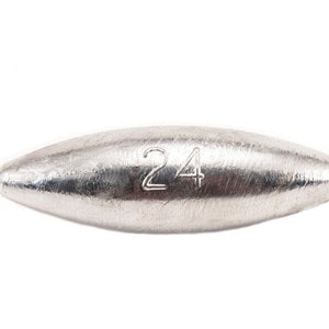 May include: A silver-colored fishing weight with the number 24 stamped on the surface. The weight has a rounded, oblong shape with a gold-colored loop on each end. The background is plain white.
