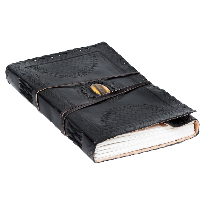 May include: A black leather-bound journal with a decorative embossed design and a tiger's eye stone closure.