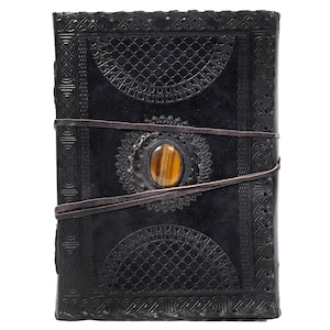 May include: Black leather journal with intricate embossed designs and a brown tiger's eye stone set in the front cover.