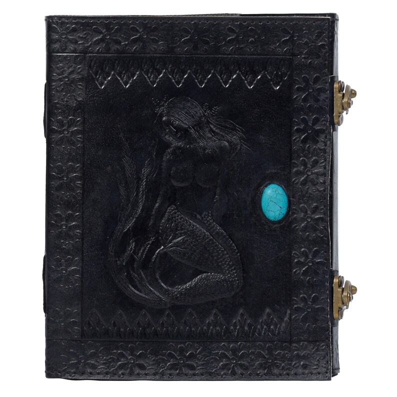 May include: Black leather journal with a mermaid embossed design and a turquoise stone inlay. The journal has two brass clasps.