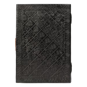 May include: Black leather journal with a decorative embossed pattern of flowers and geometric designs. The journal has a brown leather strap closure.