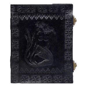 May include: Black leather journal with a mermaid embossed on the front cover. The journal has a decorative border and brass accents.