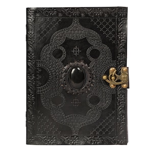 May include: Black leather journal with an intricate embossed design and a black gemstone clasp. The journal has a brass lock and keyhole.