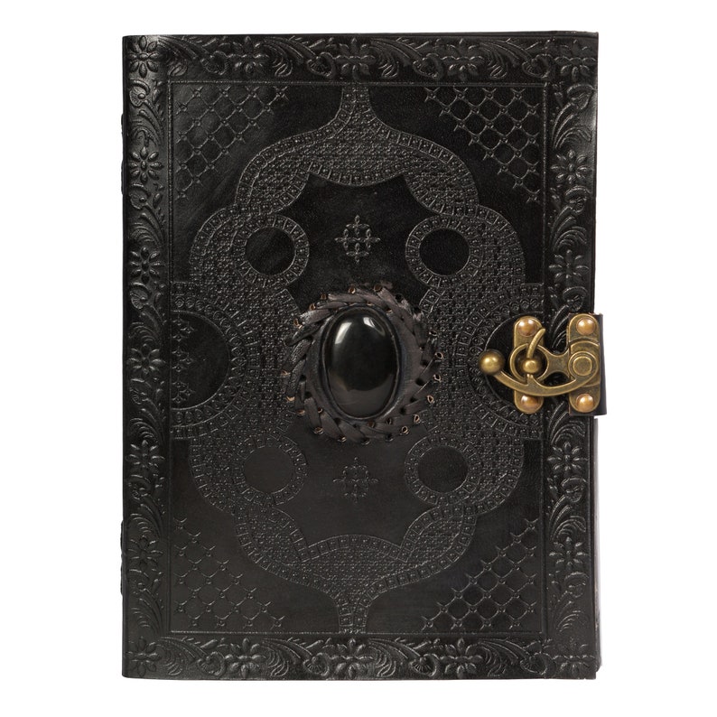 May include: Black leather journal with an intricate embossed design and a black gemstone clasp. The journal has a brass lock and keyhole.