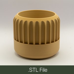 May include: A beige ceramic planter with a ribbed design. The planter has a smooth, rounded bottom.