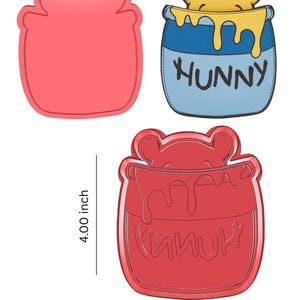 May include: Three red Winnie the Pooh-themed cookie cutters. One is a jar shape, another is a jar with a bear, and the third is a jar with the word "Hunny". The jar is 4.00 inches tall and 3.35 inches wide.