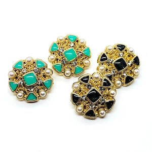 Metal, rhinestones, faux gold colored setting, pearl button, diamond button, green rhinestones, black rhinestones, shank style
