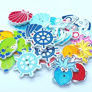 May include: A collection of colourful wooden buttons with nautical themes. The buttons feature images of anchors, seashells, steering wheels, and sea creatures.