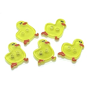 Peut inclure: Cinq boutons jaunes en forme de canard avec des pieds et des becs rouges. Chaque bouton a deux petits trous et une finition claire et brillante. Idéal pour les projets de couture et d'artisanat.