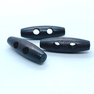 Peut inclure: Trois boutons à bascule en bois brun foncé avec deux trous chacun. Les boutons sont de forme ovale et ont une finition lisse.