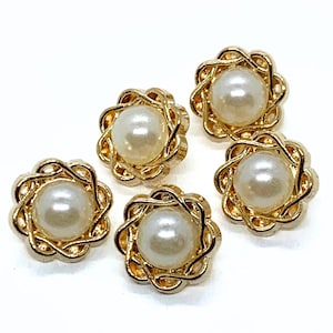 May include: Five decorative buttons with a pearl centre and a gold-coloured, floral-shaped frame. The buttons are arranged on a white background, showcasing their design and details. These buttons are suitable for sewing and craft projects.