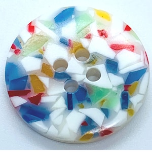 Peut inclure: Un bouton blanc avec un motif de confettis colorés. Le bouton a quatre trous et est en plastique.