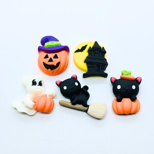 Peut inclure: Cinq décorations sur le thème d'Halloween : un fantôme, un chat noir sur un balai, une citrouille avec un chapeau de sorcière, une citrouille avec un chat noir et un château noir avec une lune croissante.