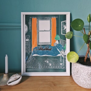May include: A framed illustration of a bedroom interior with a bed, two dogs sleeping on the bed, a lamp, and a window. The walls are green, the curtains are orange, and the bedspread is blue.