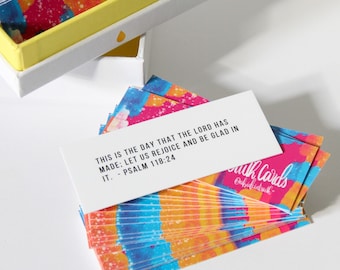 May include: A stack of colorful cards with a white card on top. The white card has a bible verse printed on it: "This is the day that the Lord has made: Let us rejoice and be glad in it. - Psalm 118:24". The bottom of the stack of cards has the words "Faith Cards" printed on it.