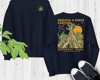May include: Navy blue sweatshirt featuring a graphic print of a mountain range and the text "Sequoia & Kings Canyon National Park, California, USA".