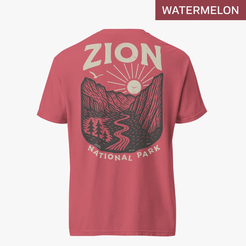 May include: A red t-shirt with a graphic of a mountain range, a river, and a sun. The text "Zion National Park" is printed below the graphic.