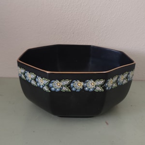 May include: A black octagonal bowl with a gold rim and a blue and white floral design.