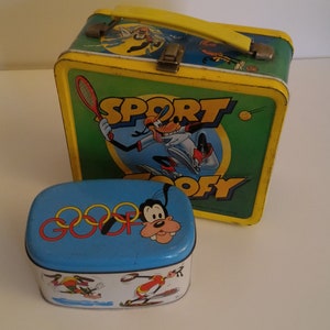 May include: Two vintage metal lunchboxes featuring Goofy. The larger lunchbox is yellow with green and blue accents and says "Sport Goofy". The smaller lunchbox is blue with red and yellow accents and says "Goofy".