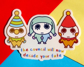 May include: A sticker featuring three cartoon figures with sad expressions. The figures are dressed in colorful outfits, with one wearing a striped hat and another a red hat. The text "the council will now decide your fate" is below them.