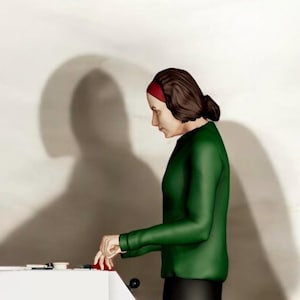 Könnte beinhalten: Eine Person mit einem grünen Langarmshirt und einem roten Stirnband arbeitet an einem weißen Tisch. Der Schatten der Person wird an die Wand dahinter geworfen. Auf dem Tisch befinden sich kleine Gegenstände.