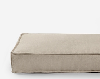 May include: A rectangular beige dog bed with a thick, padded cushion and a simple, modern design.