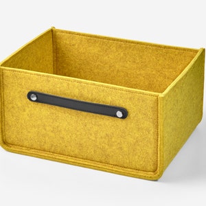 May include: A yellow felt storage box with a black leather handle and silver metal accents.