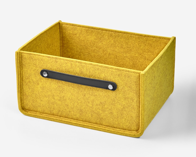 May include: A yellow felt storage box with a black leather handle and silver metal accents.